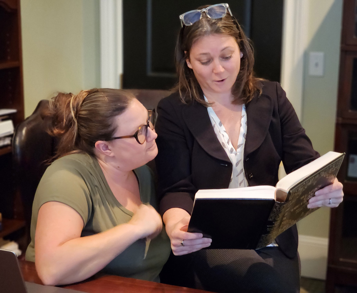 Cynthia and Tayla looking at a book.