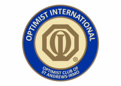 A circular blue and gold emblem with a stylized “O” and column in the center, surrounded by the words “Optimist International” and “Optimist Club of St Andrews–Irmo.”